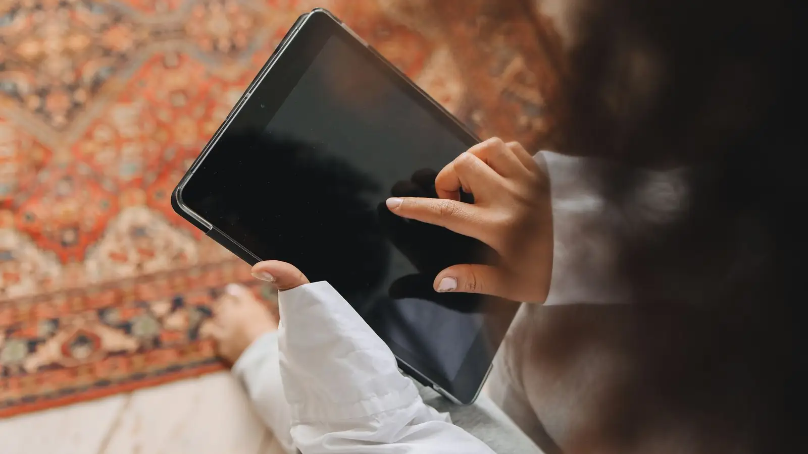 Manos usando una tableta en casa